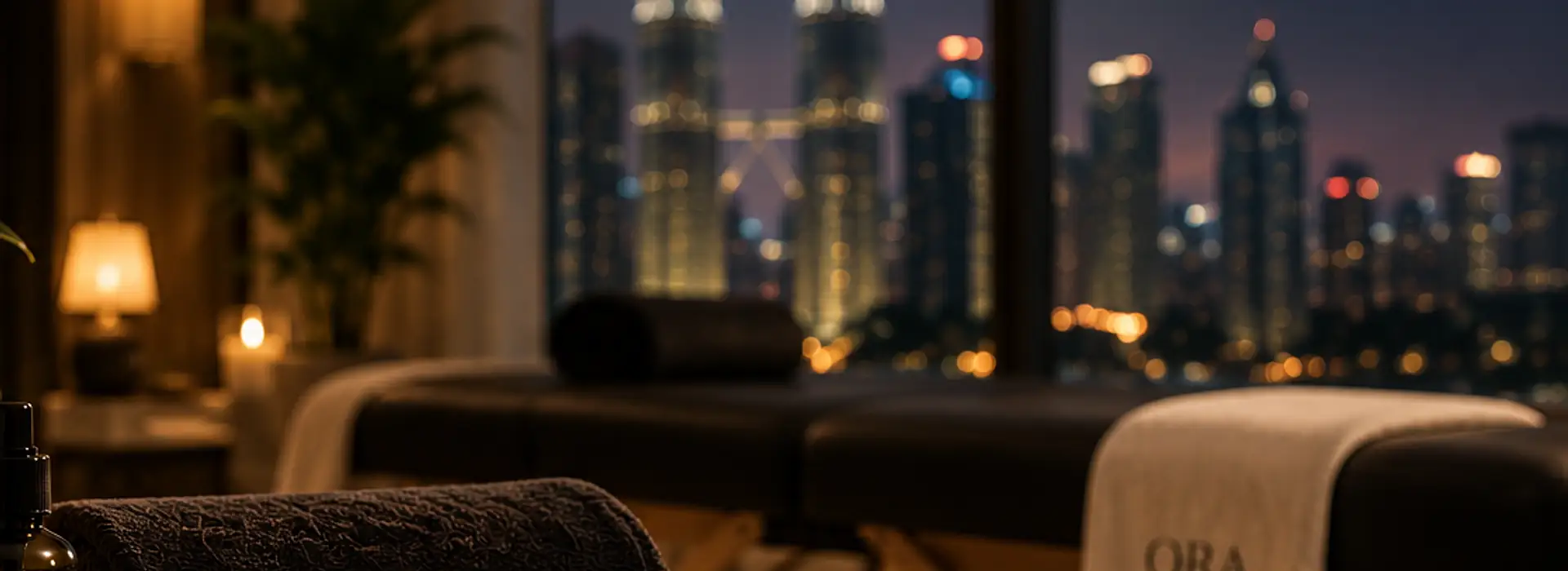 A treatment space set up by a window, with the Kuala Lumpur skyline at night